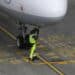 A ground crew member connects a fuel hose to an Airbus A321 aircraft