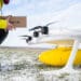 A man holds a box alongside a cargo drone