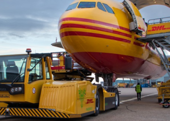 An electric GSE vehicle servicing a DHL plane